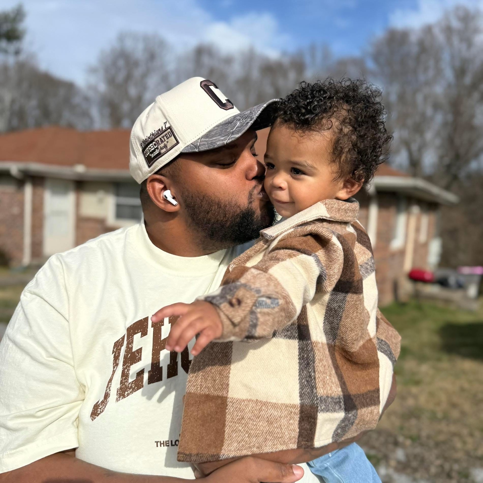 Keese Rucker holding and kissing his young son